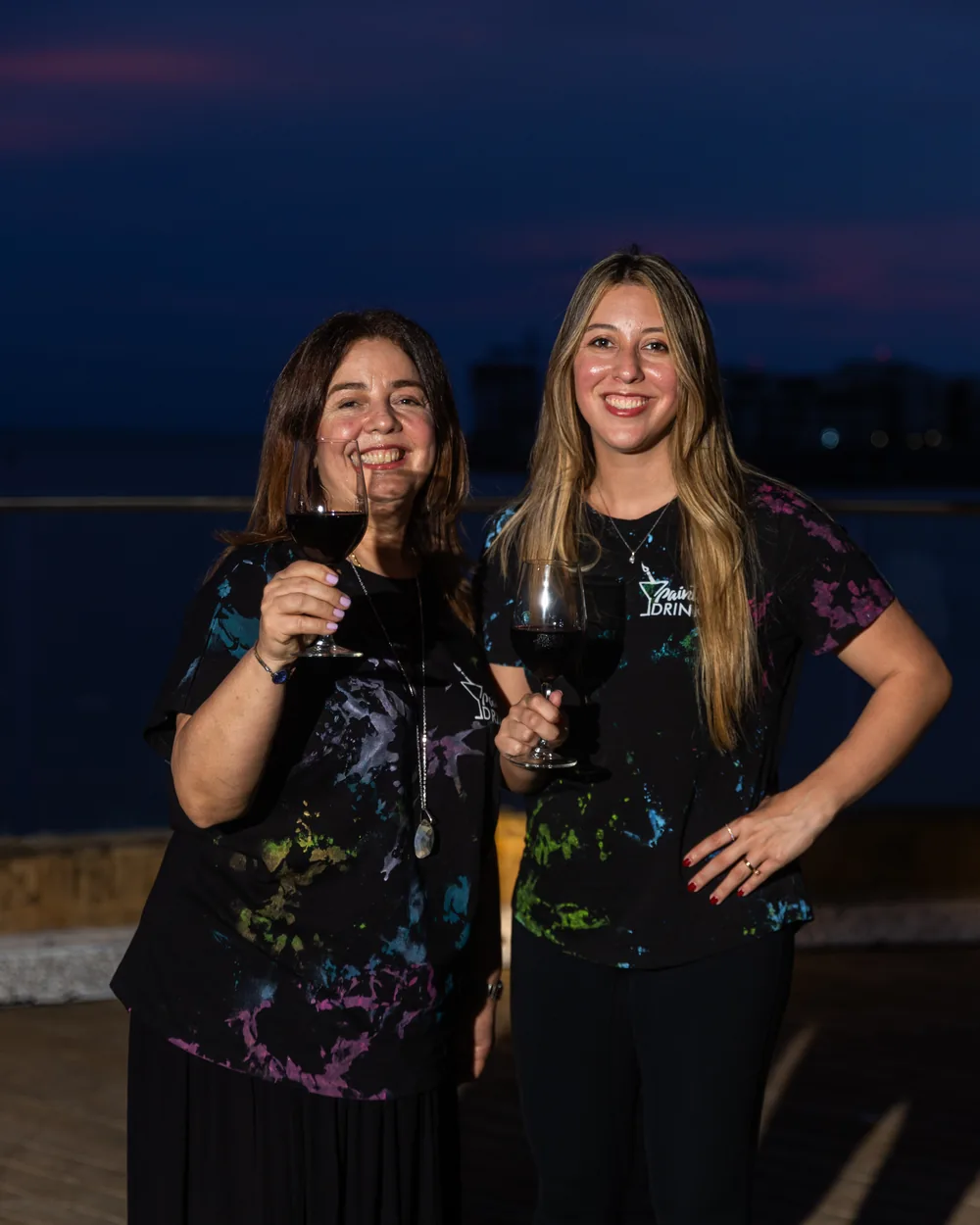 Irgia Barros y Jessica Vaca, madre e hija fundadoras de Paints & Drinks, brindando al atardecer en la celebración del 9no aniversario
