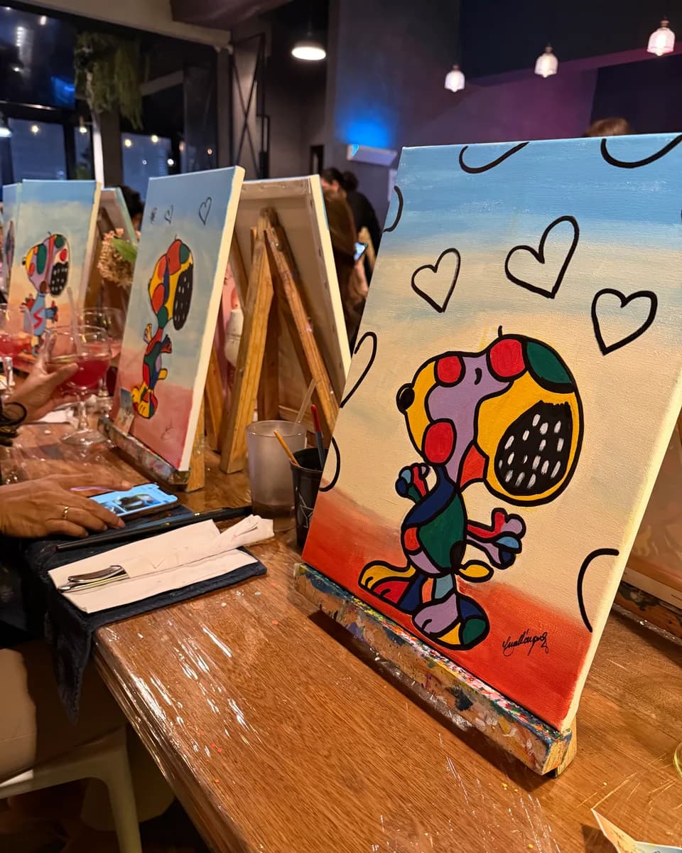 Lienzo de Snoopy con corazones sobre el caballete, pintado en una noche temática de Paints & Drinks